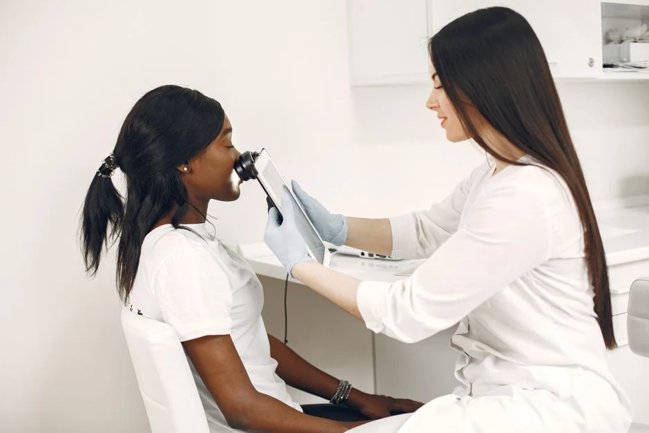 Skin specialist evaluating a patient's face before selecting laser settings